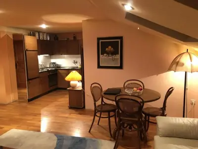 a living room with a table and chairs and a kitchen at Loli Caffe Apartment in Prokuplje