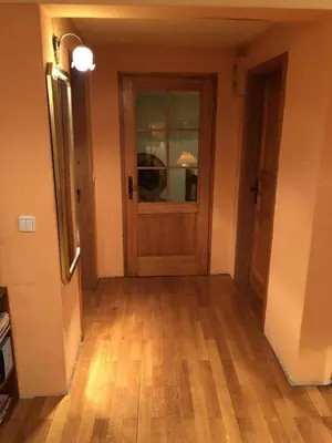 an empty hallway with a wooden door and wooden floors at Loli Caffe Apartment in Prokuplje