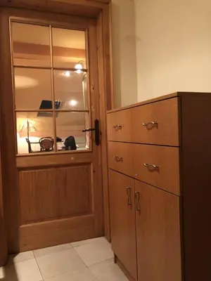 a room with a cabinet and a cat sitting in a window at Loli Caffe Apartment in Prokuplje