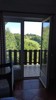 a sliding glass door with a view of a porch at Vikendica Kop in Kopaonik