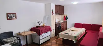 a living room with a red couch and a table at Vikendica Kop in Kopaonik
