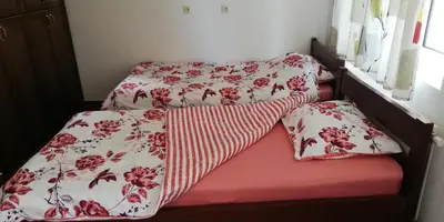 two beds with red and white blankets and pillows at Vikendica Kop in Kopaonik