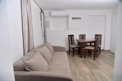 a living room with a couch and a table with chairs at Apartmani Milovanović in Vrnjačka Banja