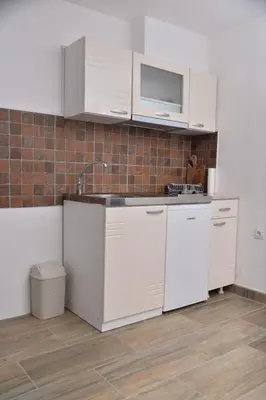 a kitchen with white cabinets and a sink at Apartmani Milovanović in Vrnjačka Banja