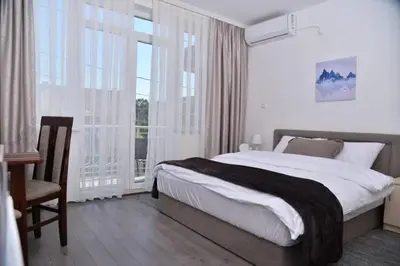 a bedroom with a bed and a large window at Apartmani Milovanović in Vrnjačka Banja