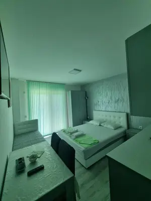 a hotel room with two beds and a table at Bovan GREEN LAKE apartments in Soko Banja