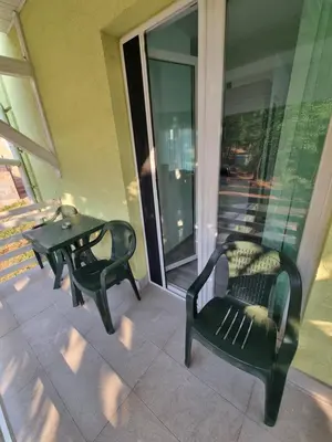 two green chairs and a table on a balcony at Bovan GREEN LAKE apartments in Soko Banja