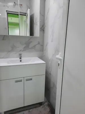 a white bathroom with a sink and a mirror at Bovan GREEN LAKE apartments in Soko Banja