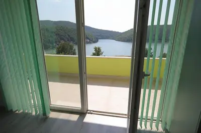 an open door with a view of a lake from a balcony at Bovan GREEN LAKE apartments in Soko Banja