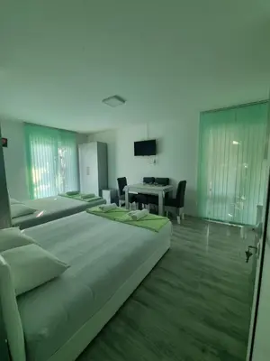 a bedroom with three beds and a desk and a table at Bovan GREEN LAKE apartments in Soko Banja