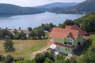 a house on a hill with a view of a lake at Bovan GREEN LAKE apartments in Soko Banja