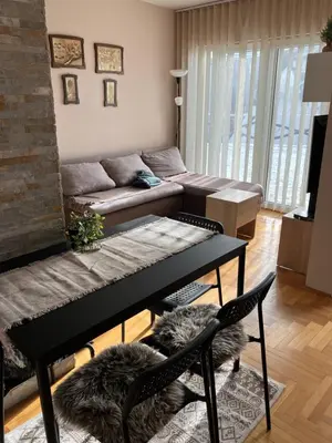 a living room with a table and a couch at Zoara apartment in Kopaonik