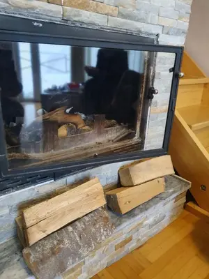 a pile of logs sitting on top of a fireplace at Zoara apartment in Kopaonik