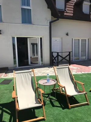 two chairs and a table on a lawn at Zoara apartment in Kopaonik
