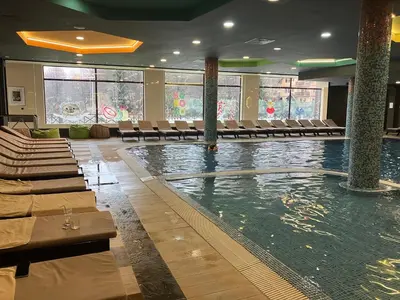 a swimming pool in a hotel with chairs and tables at Zoara apartment in Kopaonik