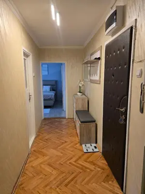 a hallway with a black door and a wooden floor at Kingston in Pirot
