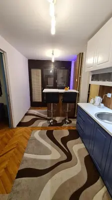 a kitchen with a counter and two stools in a room at Kingston in Pirot