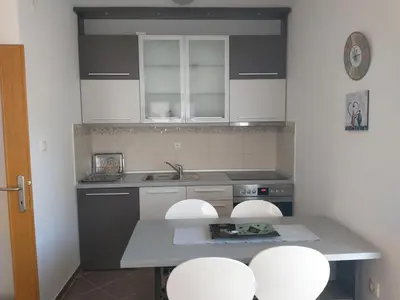 a kitchen with white cabinets and a sink and stools at Apartment Park in Vrnjačka Banja