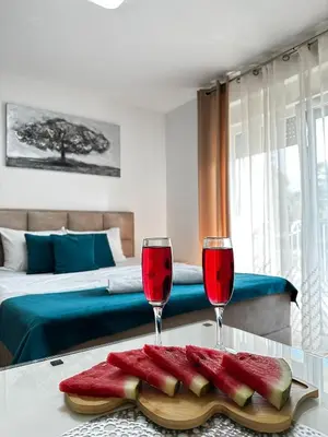 two glasses of red wine on a table in a bedroom at Studio Bogdanovic in Vrnjačka Banja