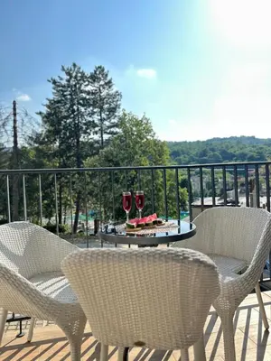a table with two glasses of wine on a balcony at Studio Bogdanovic in Vrnjačka Banja
