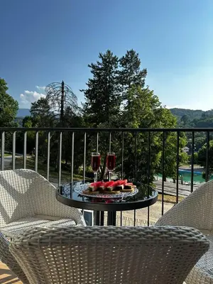 a table with two glasses of wine on a balcony at Studio Bogdanovic in Vrnjačka Banja