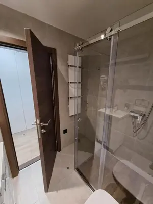 a bathroom with a glass shower with a toilet at Apartman ZoneS - Zoned in Kopaonik