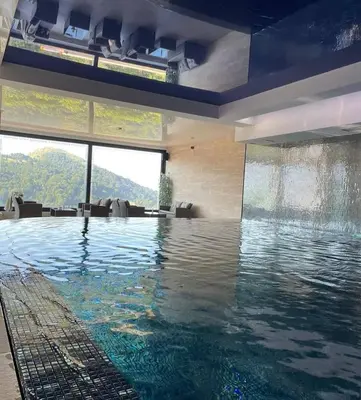a swimming pool in a building with a view of a mountain at Apartman ZoneS - Zoned in Kopaonik