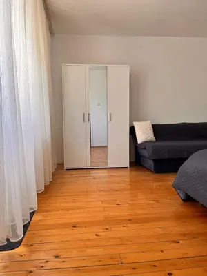 a living room with a couch and a mirror at Apartman Lili in Soko Banja