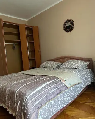 a bedroom with a bed and a clock on the wall at Apartman Lili in Soko Banja