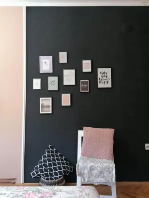 a room with a black wall with a chair and pictures at Apartman Lili in Soko Banja