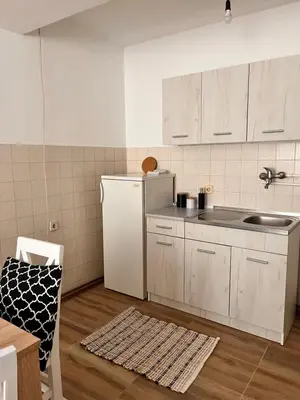 a kitchen with white cabinets and a white refrigerator at Apartman Lili in Soko Banja
