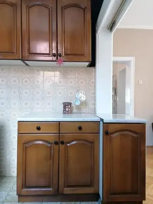 a kitchen with wooden cabinets and a counter top at Apartman Lili in Soko Banja