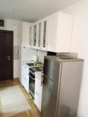 a kitchen with a stainless steel refrigerator and white cabinets at Apartman Sveta in Vrnjačka Banja