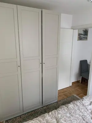a bedroom with white cabinets and a bed at Apartman Sveta in Vrnjačka Banja