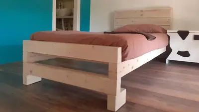 a bed with a wooden bed frame in a room at Village house Moo Moo in Vranje