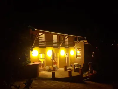 a house with lights on the side of it at night at Village house Moo Moo in Vranje