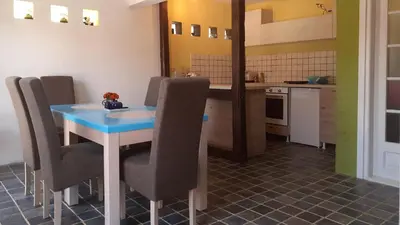 a kitchen with a blue table and chairs in a room at Village house Moo Moo in Vranje
