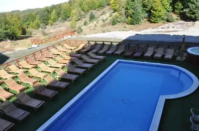 a swimming pool with chaise lounge chairs and a resort at Lux apartment A38, Kraljevi čardaci, Kopaonik in Kopaonik
