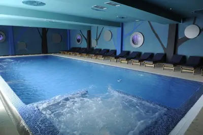 a large swimming pool with chairs in a room at Lux apartment A38, Kraljevi čardaci, Kopaonik in Kopaonik