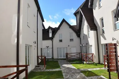 a row of white buildings with grass between them at Lux apartment A38, Kraljevi čardaci, Kopaonik in Kopaonik