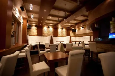 a restaurant with white chairs and tables and a bar at Silver View in Kopaonik