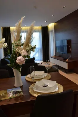 a living room with a table with flowers and a television at Silver View in Kopaonik