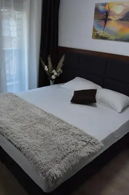 a bed with a blanket and a vase of flowers on it at Silver View in Kopaonik