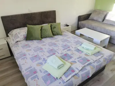 a bedroom with a bed and a couch at Apartmani Manila, Vrnjačke terme-popust, SPA centar Pegaz-popust, garažno mesto in Vrnjačka Banja