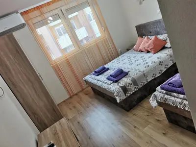 a small bedroom with a bed and a door at Apartmani Manila, Vrnjačke terme-popust, SPA centar Pegaz-popust, garažno mesto in Vrnjačka Banja