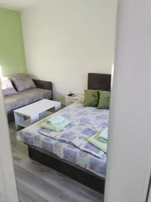 a small bedroom with a bed and a couch at Apartmani Manila, Vrnjačke terme-popust, SPA centar Pegaz-popust, garažno mesto in Vrnjačka Banja