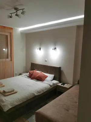 a bedroom with two beds and two lights on the wall at Apartmani Manila, Vrnjačke terme-popust, SPA centar Pegaz-popust, garažno mesto in Vrnjačka Banja