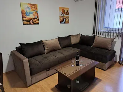 a living room with a brown couch and a table at Apartman Andjela in Soko Banja
