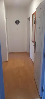 an empty hallway with white walls and a wooden floor at Apartman Andjela in Soko Banja