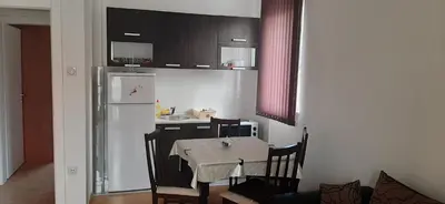 a kitchen with a table and a white refrigerator at Apartman Andjela in Soko Banja